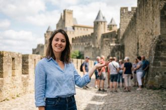 Jeune femme souriante guidant des touristes près des remparts