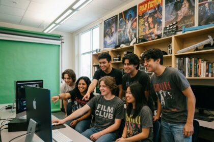 Groupe de jeunes autour d'un ordinateur en classe créative